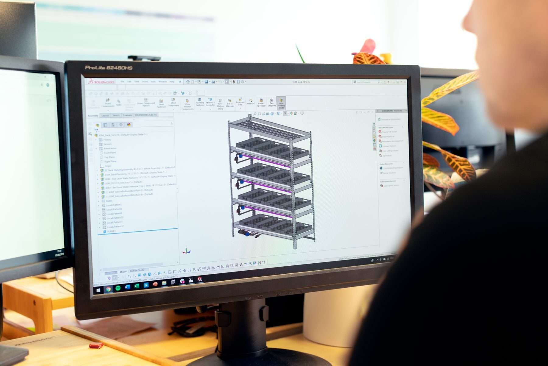 Konstrukteur arbeitet am Bildschirm an einem 3D-CAD-Modell eines Regalgestells.